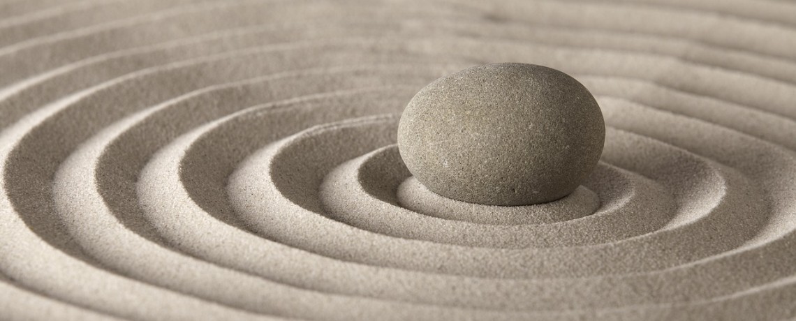 Ein Stein auf einem Sandbett, der Vibratonskreise erzeugt